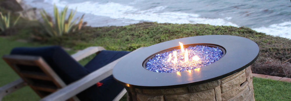 picture of cobalt blue reflective fire glass fire pit on the beach